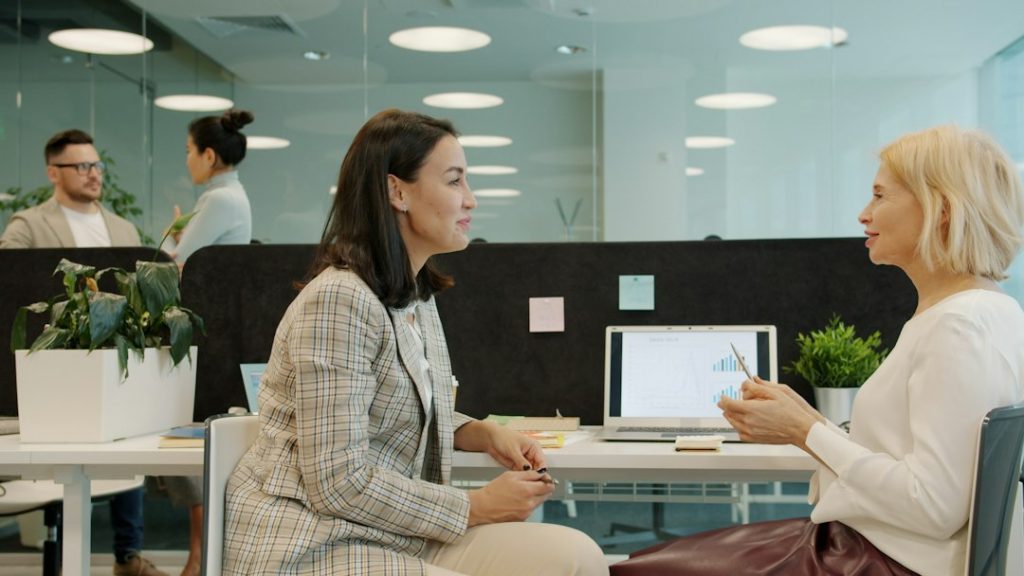 Coworkers discussing work at a laptop